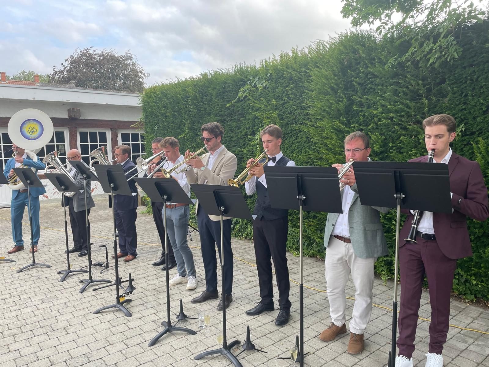 Geef Moar Buzze! speelt buiten, op een rij achter de lessenaars