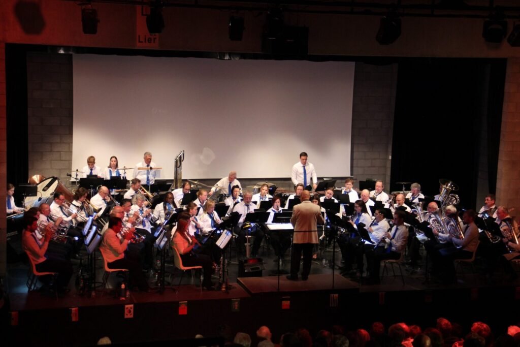 De volledige concertband op het podium, met de dirigent vooraan