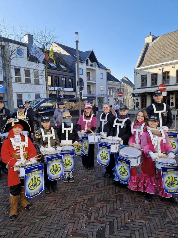Jonge tamboers in carnavalskostuum met trommels op de markt van Brakel
